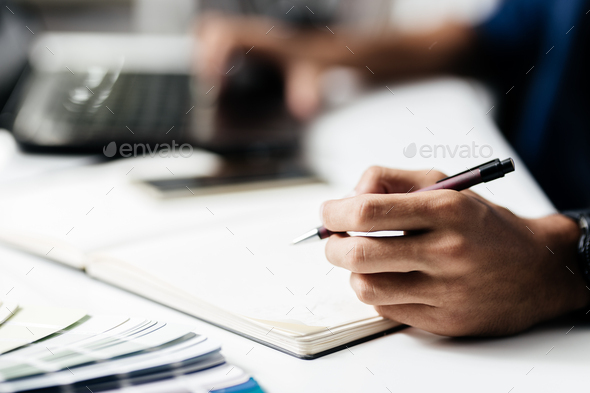 Man makes notes in a notebook on a table - Stock Photo - Images