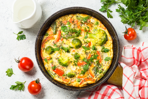 Frittata with vegetables on white stone table