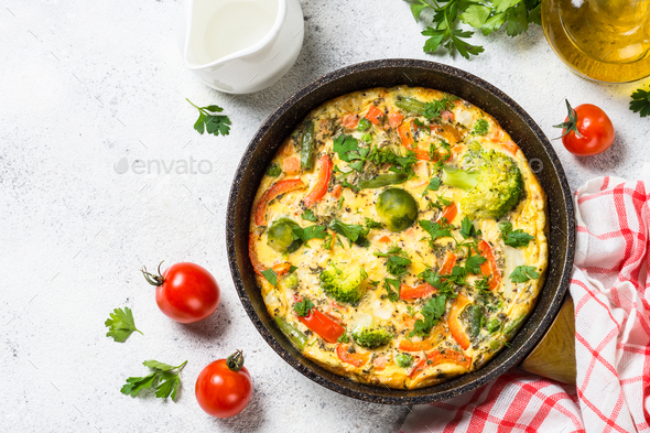 Frittata with vegetables on white stone table