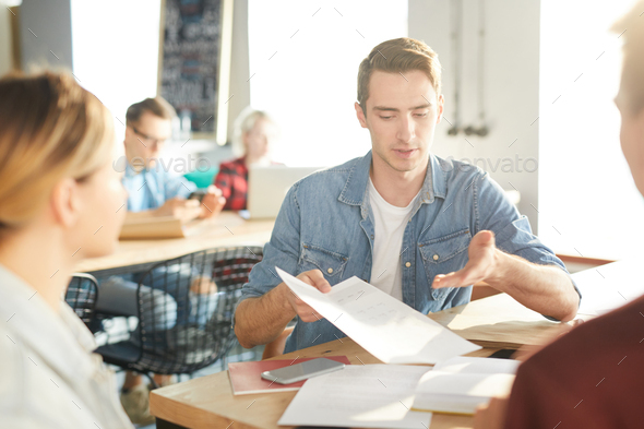 Handsome Man Presenting Document to Colleagues - Stock Photo - Images
