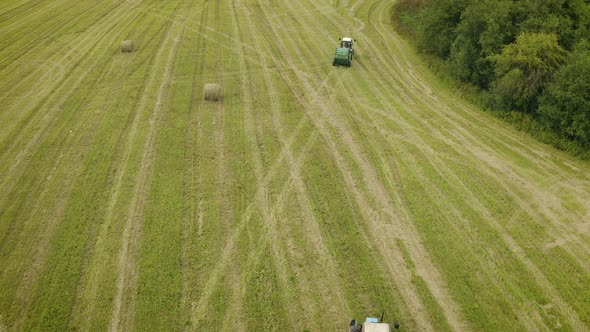 Aerial View of Two Tractors Collecting Crop Straw and Making Haystacks in Baler alt
