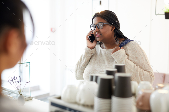 Phoning in cafeteria - Stock Photo - Images