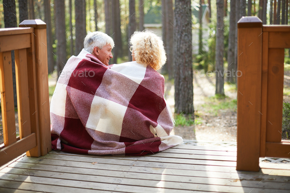 Happy senior couple sitting on porch - Stock Photo - Images