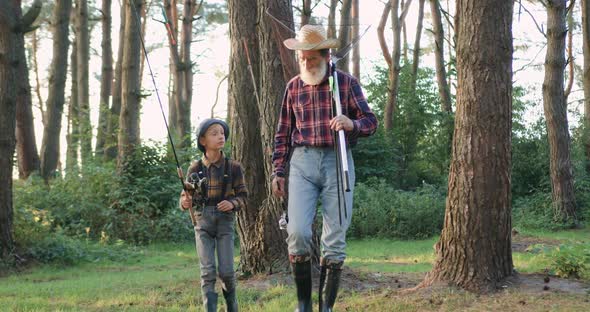 Granddad in Hat which Going Fishing with His Handsome Small Interested Grandson alt