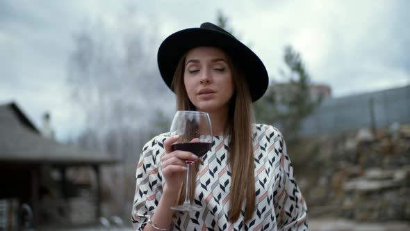 Sassy Brunette Sipping Red Wine Outdoors alt