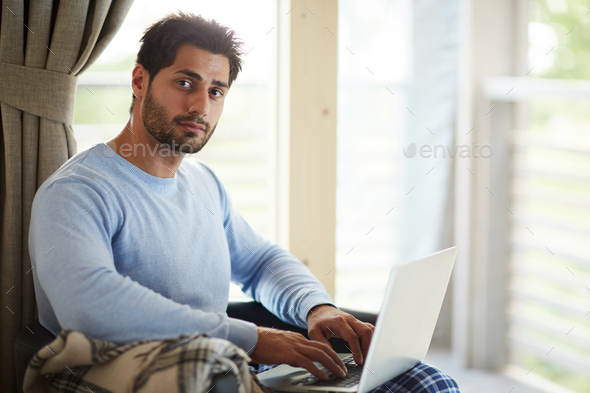 Handsome freelance community manager working at home