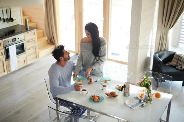 Pretty wife taking care of husband at home - Stock Photo - Images