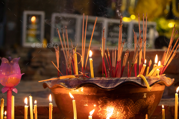 Burning incense sticks in a Buddhist Temple in Thailand. - Stock Photo - Images