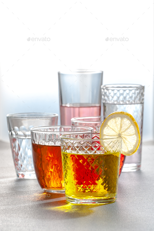 Various lemonades in glass faceted glasses on a gray table. Phot - Stock Photo - Images