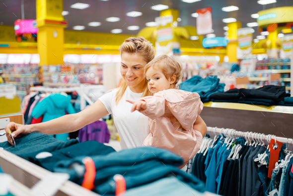 Mother with daughter choosing clothes in store