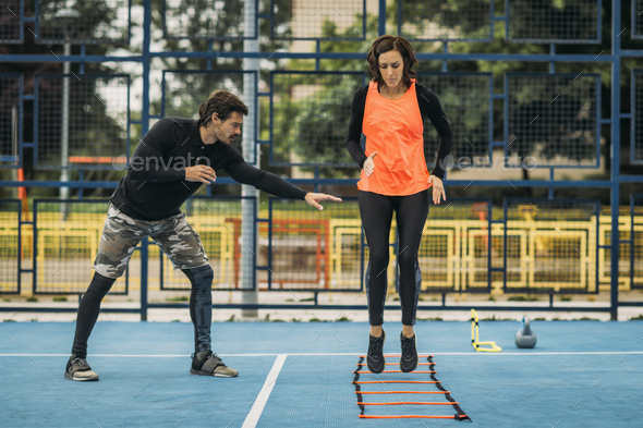Young Woman Exercise using Agility Ladder, working with Fitness Coach