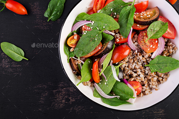 Buckwheat salad with cherry tomatoes, red onion and fresh spinach. Vegan food. Diet menu. - Stock Photo - Images