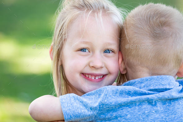 Young Brother and Sister Hugging At The Park. - Stock Photo - Images