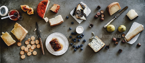 Variety of snacks and cheeses over grey background, wide composition - Stock Photo - Images