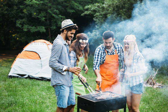 Friends spending time in nature and having barbecue - Stock Photo - Images
