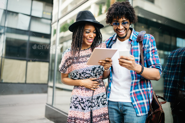 Happy young couple using a digital tablet together and smiling - Stock Photo - Images