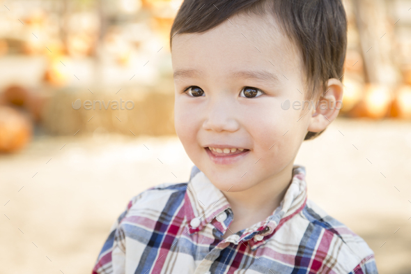 Cute Mixed Race Young Boy Having Fun at the Pumpkin Patch. - Stock Photo - Images