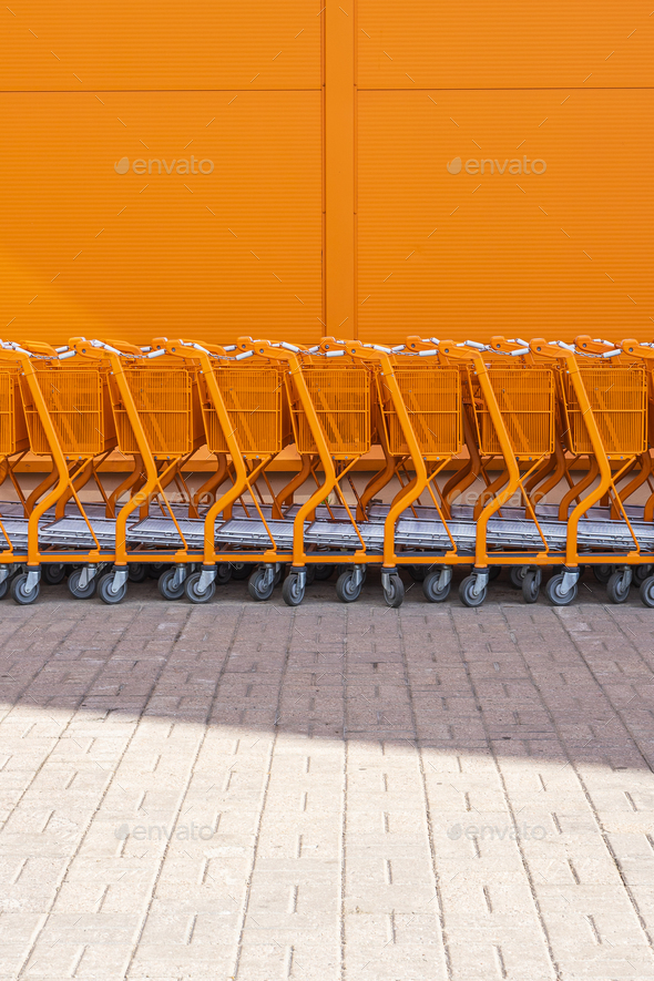 Orange shopping cart stacked by the entrance - Stock Photo - Images