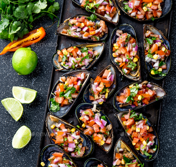 Choros a la chalaca. Big mussels seasoned with purple onion, tomatoes, corn and lemon - Stock Photo - Images
