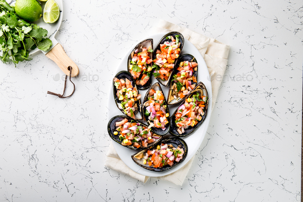 Choros a la chalaca. Big mussels seasoned with purple onion, tomatoes, corn and lemon - Stock Photo - Images