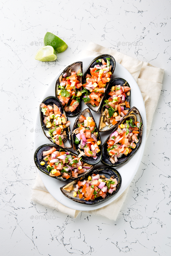 Choros a la chalaca. Big mussels seasoned with purple onion, tomatoes, corn and lemon - Stock Photo - Images