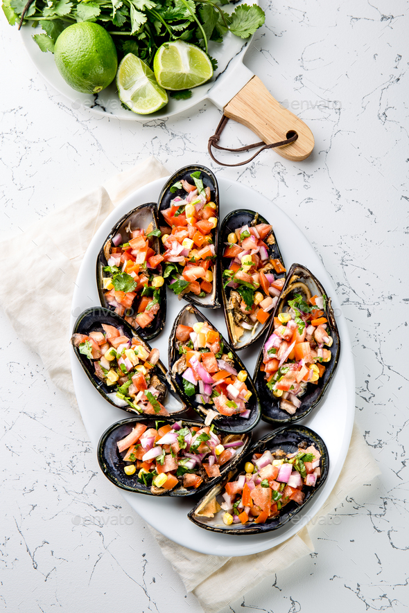 Choros a la chalaca. Big mussels seasoned with purple onion, tomatoes, corn and lemon - Stock Photo - Images