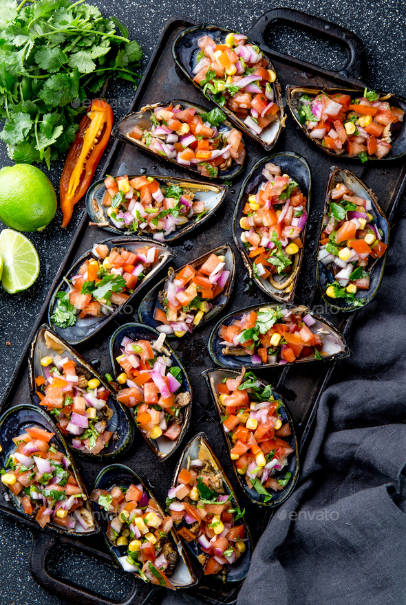 Big mussels, choros zapatos seasoned with purple onion, tomatoes, corn and lemon - Stock Photo - Images