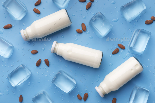 Healthy and vegetarian almond milk in glass jars on blue - Stock Photo - Images