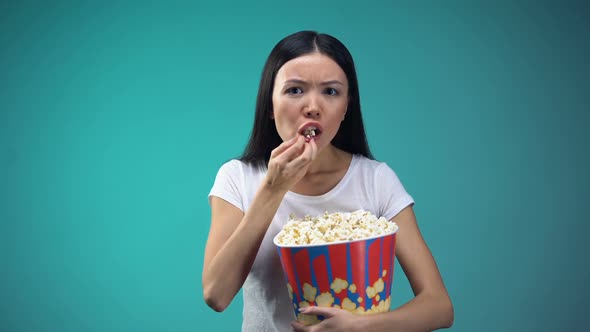 Focused on Movie Woman Devouring Popcorn From Big Paper Cup, Unhealthy Eating alt