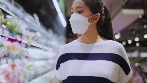 asian female woman wearing protective face mask  in groceries store