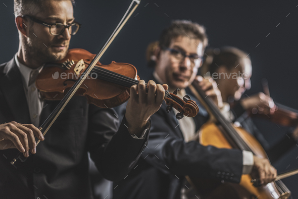 Symphonic string orchestra performing on stage - Stock Photo - Images