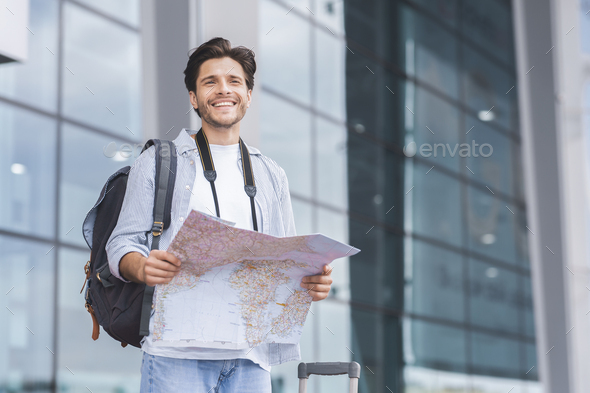 Millennial tourist looking for route on map at airport