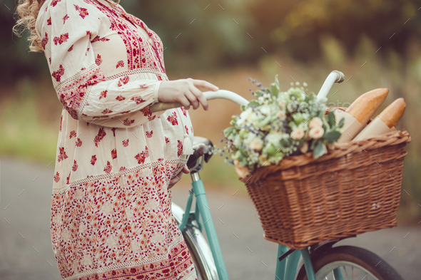 Pregnant belly against nature close-up. Woman retro French style with bicycle on a forest road - Stock Photo - Images