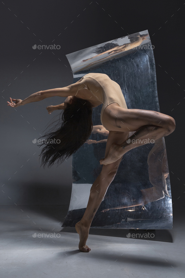Young and stylish modern ballet dancer on grey background