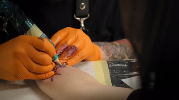 Tattoo Artist Draws a Picture on the Hand of a Young Woman, the Process of Creating a Tattoowith alt