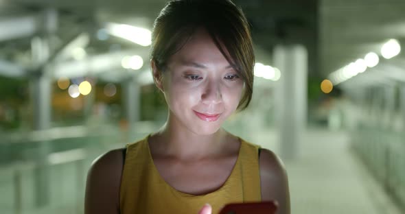 Woman use of mobile phone in city at night alt