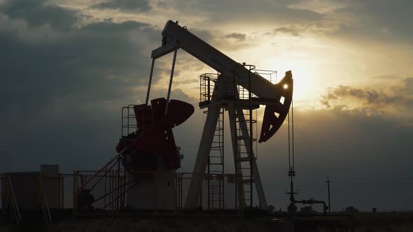 Oil Mining an Oil Rig in the Field Pumps Out Oil View of an Oil Rig at Sunset Resource Extraction alt