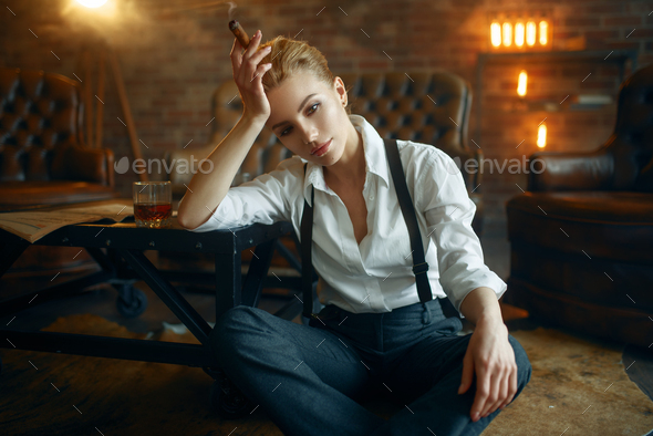 Woman sitting on the floor with whiskey and cigar