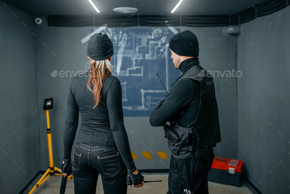 Two robbers working on a plan to rob the vault