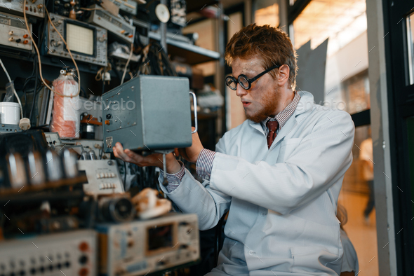 Scientist in glasses holds electrical device