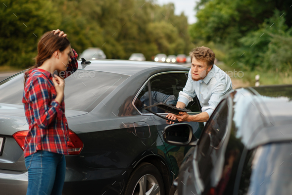 Male and female drivers on road, car accident - Stock Photo - Images