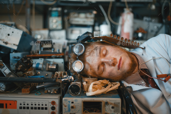 Strange engineer sleeping on devices in lab