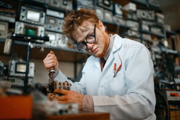 Strange scientist works with soldering iron in lab