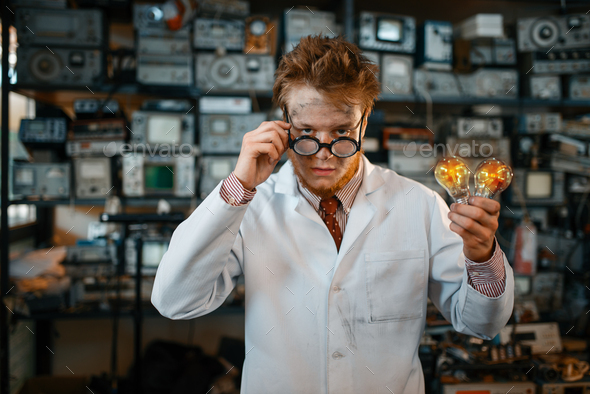 Strange engineer holds electric lamp in laboratory