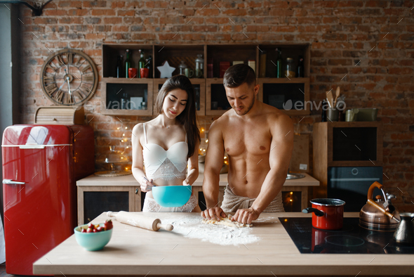 Young couple in underwear cooking on the kitchen - Stock Photo - Images