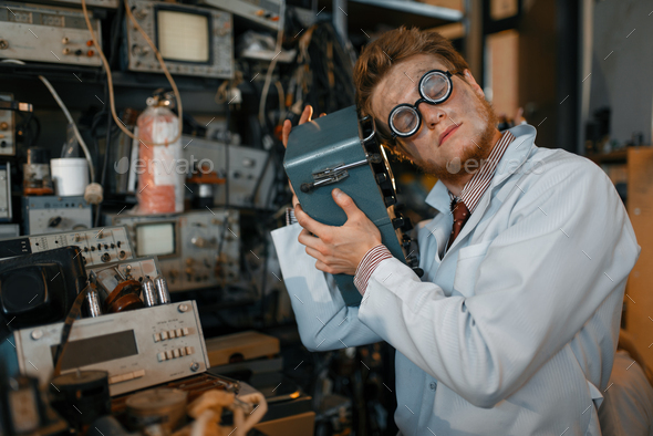 Scientist in glasses holds electrical device