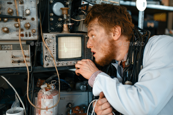 Engineer looks on oscilloscope display in lab - Stock Photo - Images