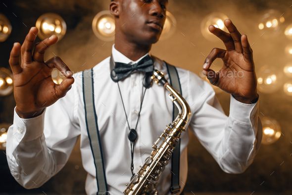 Black jazz performer with saxophone shows OK sign - Stock Photo - Images