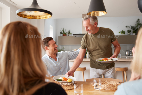 Family With Senior Parents And Adult Offspring Eating Brunch Around Table At Home Together