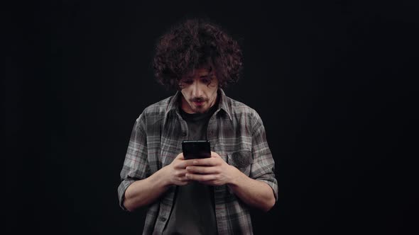 The Charismatic Young Man Seriously Looks on the Phone After Which He Receives a Message That Makes alt